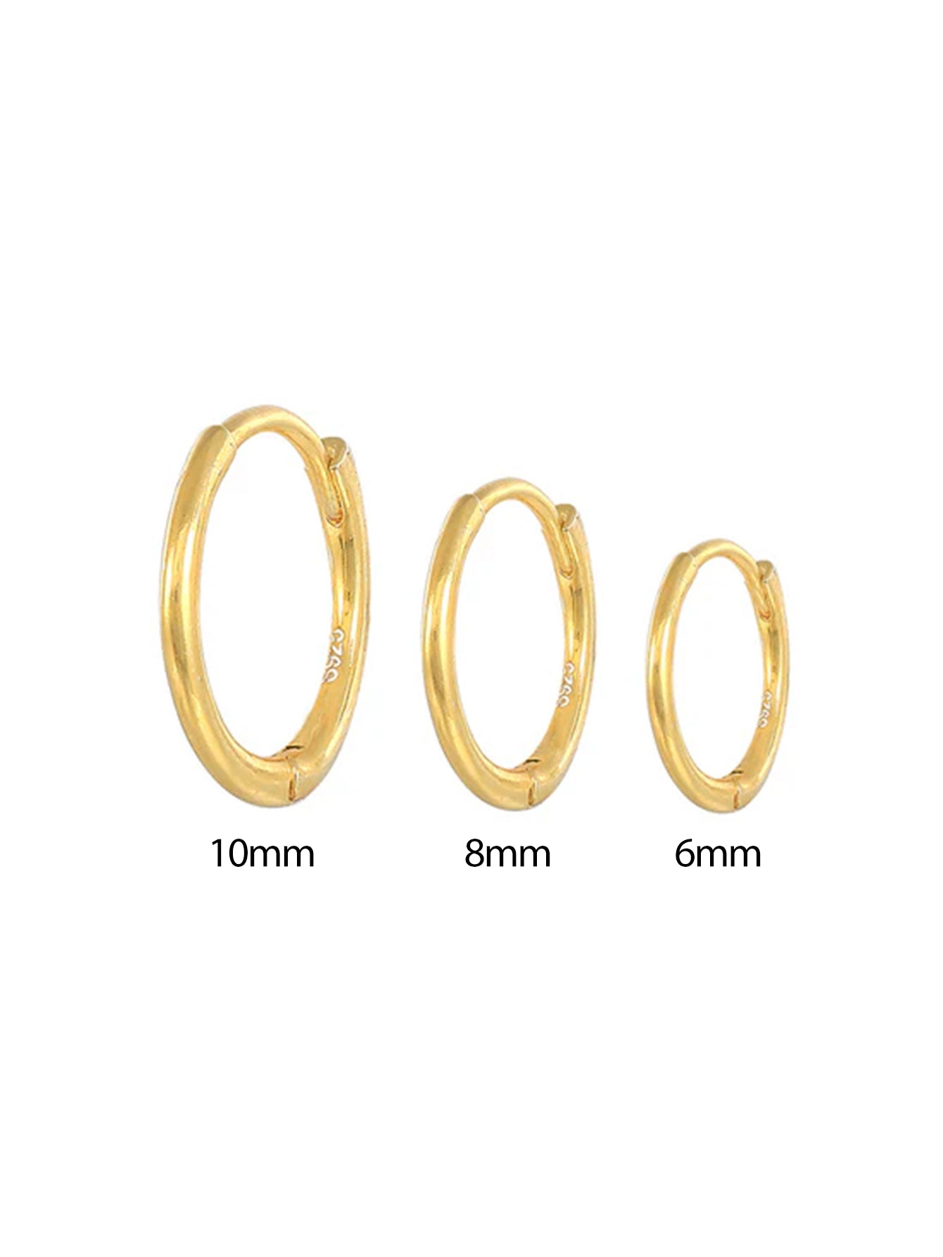 Emilie – Finom arany fülbevalók lágy fényben.