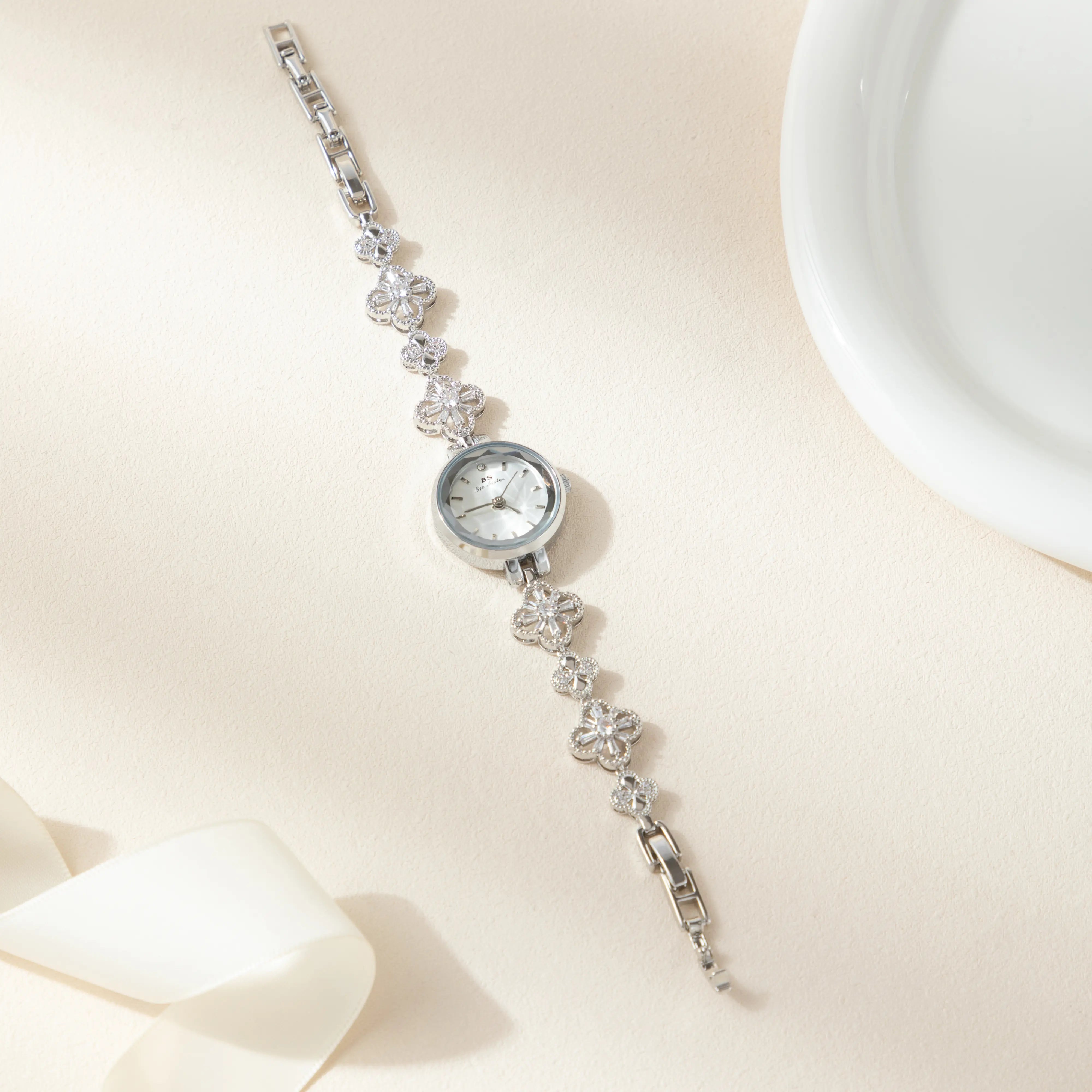 Elina – Arany színű óra virágmintás karkötővel.