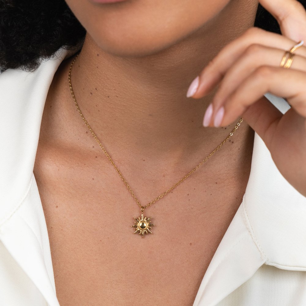 Ronja – Arany színű nyaklánc virágos medállal.